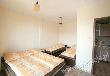 Sypialnia w apartamencie nr 5. Wygodne łoże małżeńskie i łóżka hotelowe.